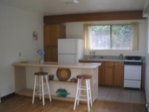 339 Ainakula Road Kula, HI 96790 - Photo 16 of 20 a kitchen with granite countertop wooden cabinets and a table