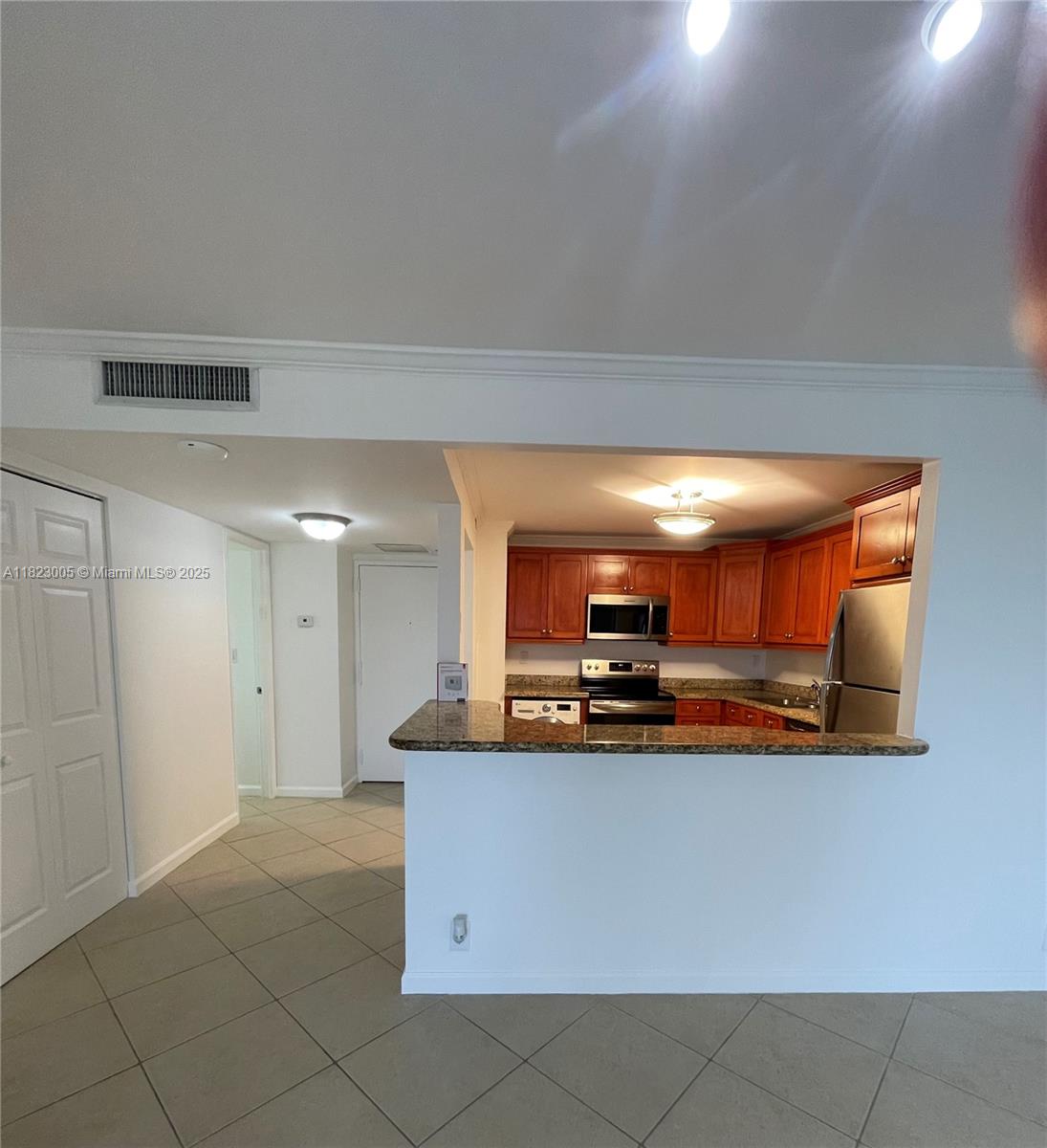 Brickell Place Miami, FL 33129 - Photo 22 of 24 a kitchen with kitchen island granite countertop a stove top oven a sink and a granite counter top