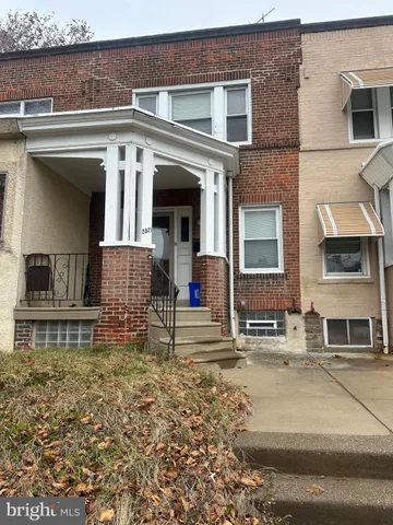 front view of a brick house with a small yard