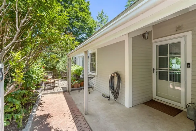 a view of a patio with chairs and potted plants