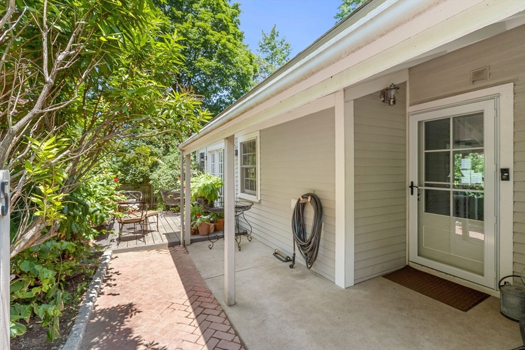 165 Highland Street, Unit 165 Dedham, MA 02026 - Photo 31 of 40 a view of a patio with table and chairs and potted plants