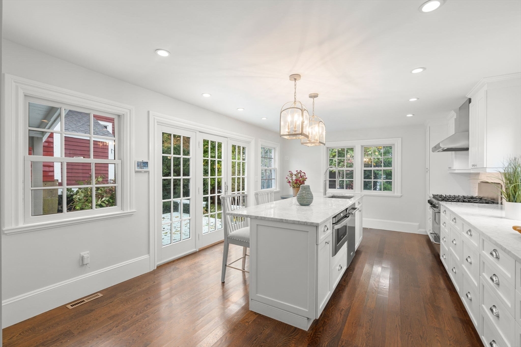 165 Highland Street, Unit 165 Dedham, MA 02026 - Photo 5 of 40 a large kitchen with kitchen island a large window a sink and stainless steel appliances