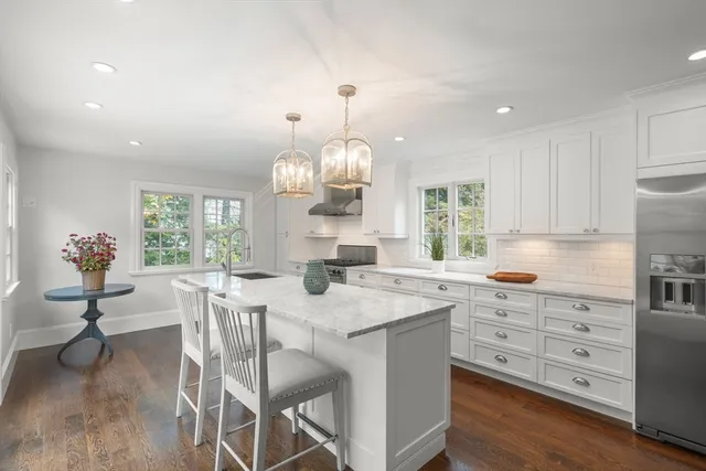 a kitchen with granite countertop a stove a table and chairs in it