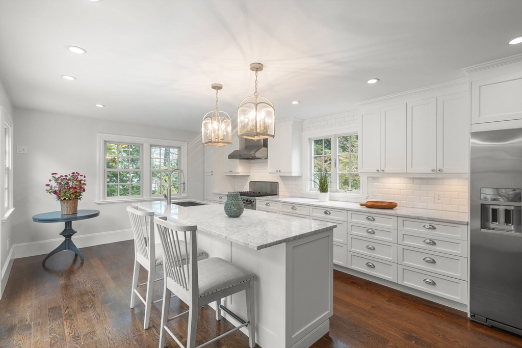 165 Highland Street, Unit 165 Dedham, MA 02026 - Photo 6 of 40 a kitchen with granite countertop a stove a table and chairs in it