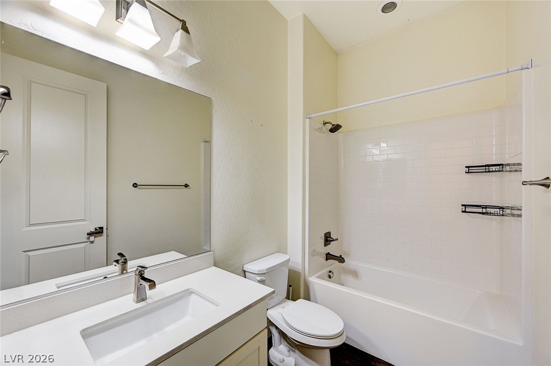 8197 Riley Love Street Las Vegas, NV 89139 - Photo 7 of 48 A pristine bathroom features a crisp white vanity and a subway-tiled tub/shower combo.