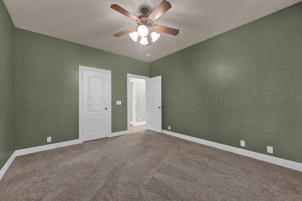 6607 Sumac Place Amarillo, TX 79124 - Photo 21 of 33 an empty room with a chandelier fan and windows