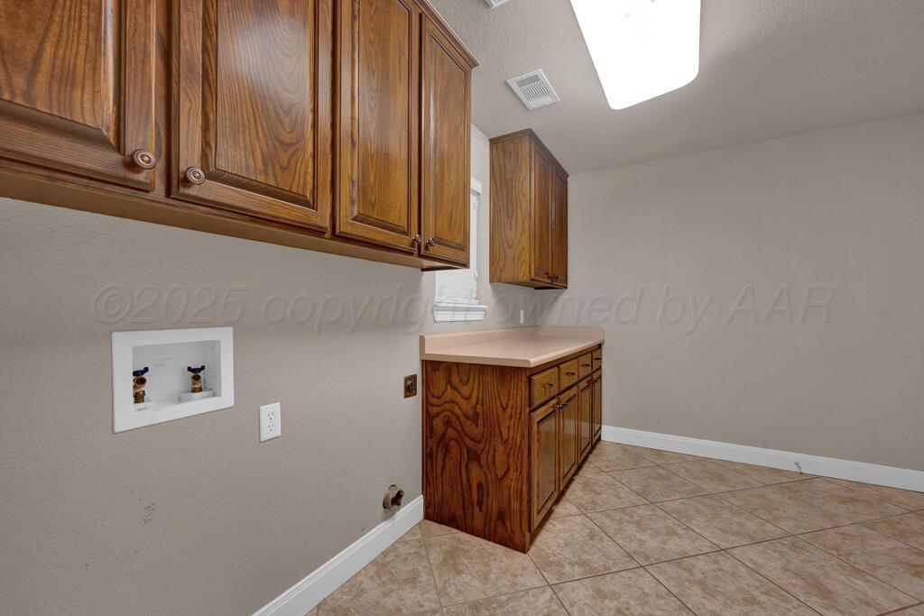 6607 Sumac Place Amarillo, TX 79124 - Photo 28 of 33 a utility room with granite countertop cabinets and washer