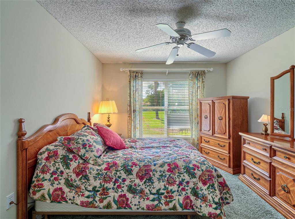 11228 Windrush Circle Hudson, FL 34667 - Photo 26 of 67 a bedroom with a large bed and a chandelier