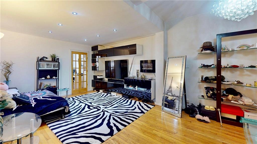 2546 East 13th Street, Unit L14 Brooklyn, NY 11235 - Photo 1 of 10 a living room with furniture or couch and a flat screen tv