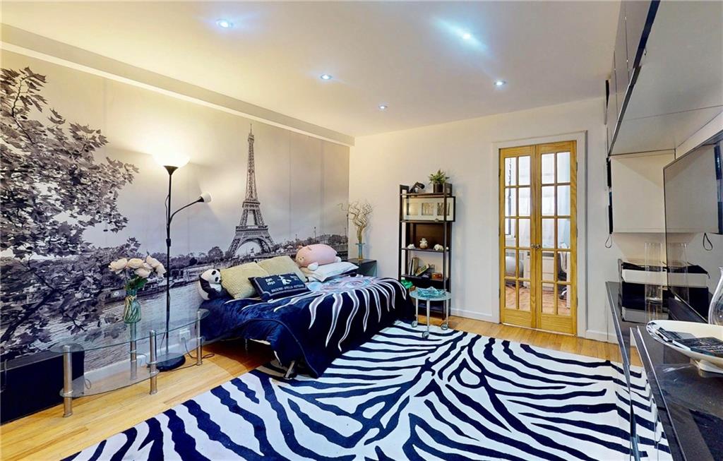 2546 East 13th Street, Unit L14 Brooklyn, NY 11235 - Photo 2 of 10 a bedroom with a bed and wooden floor