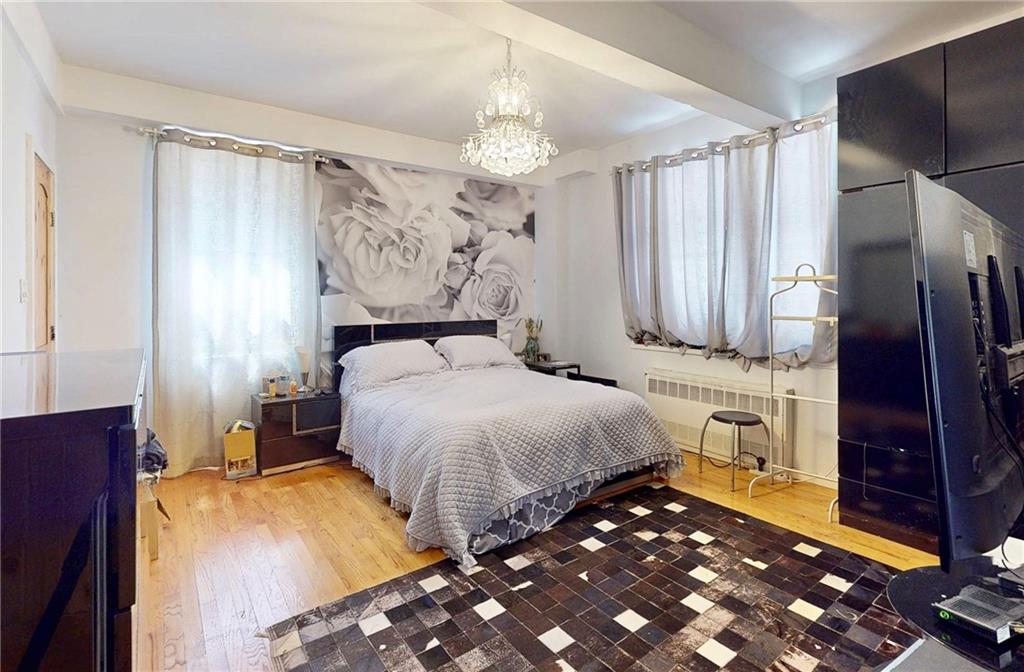 2546 East 13th Street, Unit L14 Brooklyn, NY 11235 - Photo 5 of 10 a bedroom with a bed dresser and a large mirror