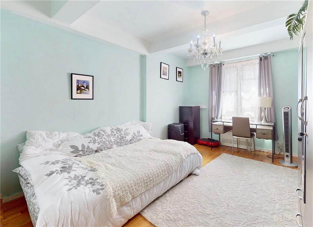 2546 East 13th Street, Unit L14 Brooklyn, NY 11235 - Photo 9 of 10 a bedroom with a bed and a chandelier
