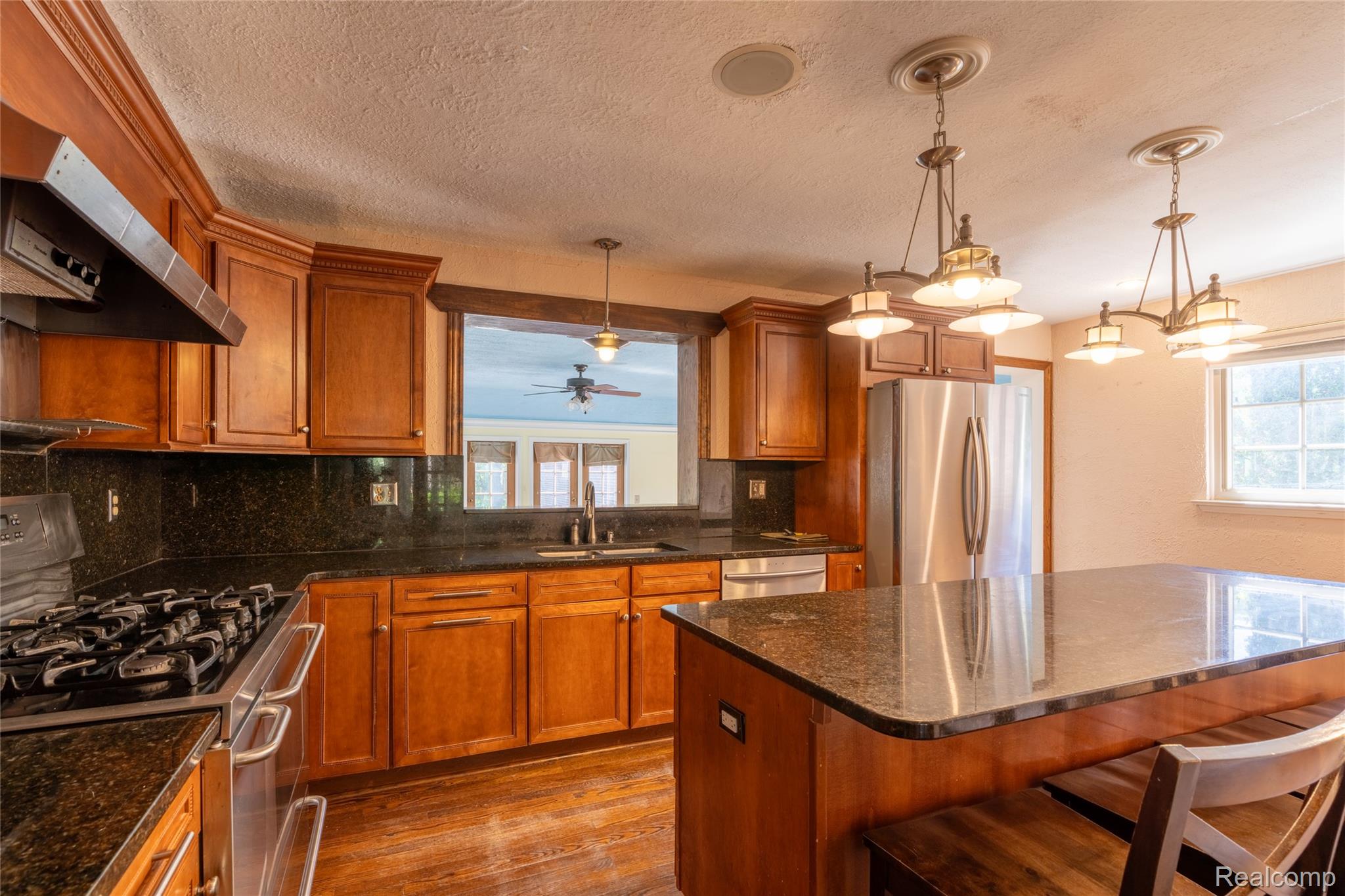1481 Oxford Road Grosse Pointe, MI 48236 - Photo 23 of 29 Warm wood cabinetry throughout featuring a gas range, built-in dishwasher, and stainless steel refrigerator