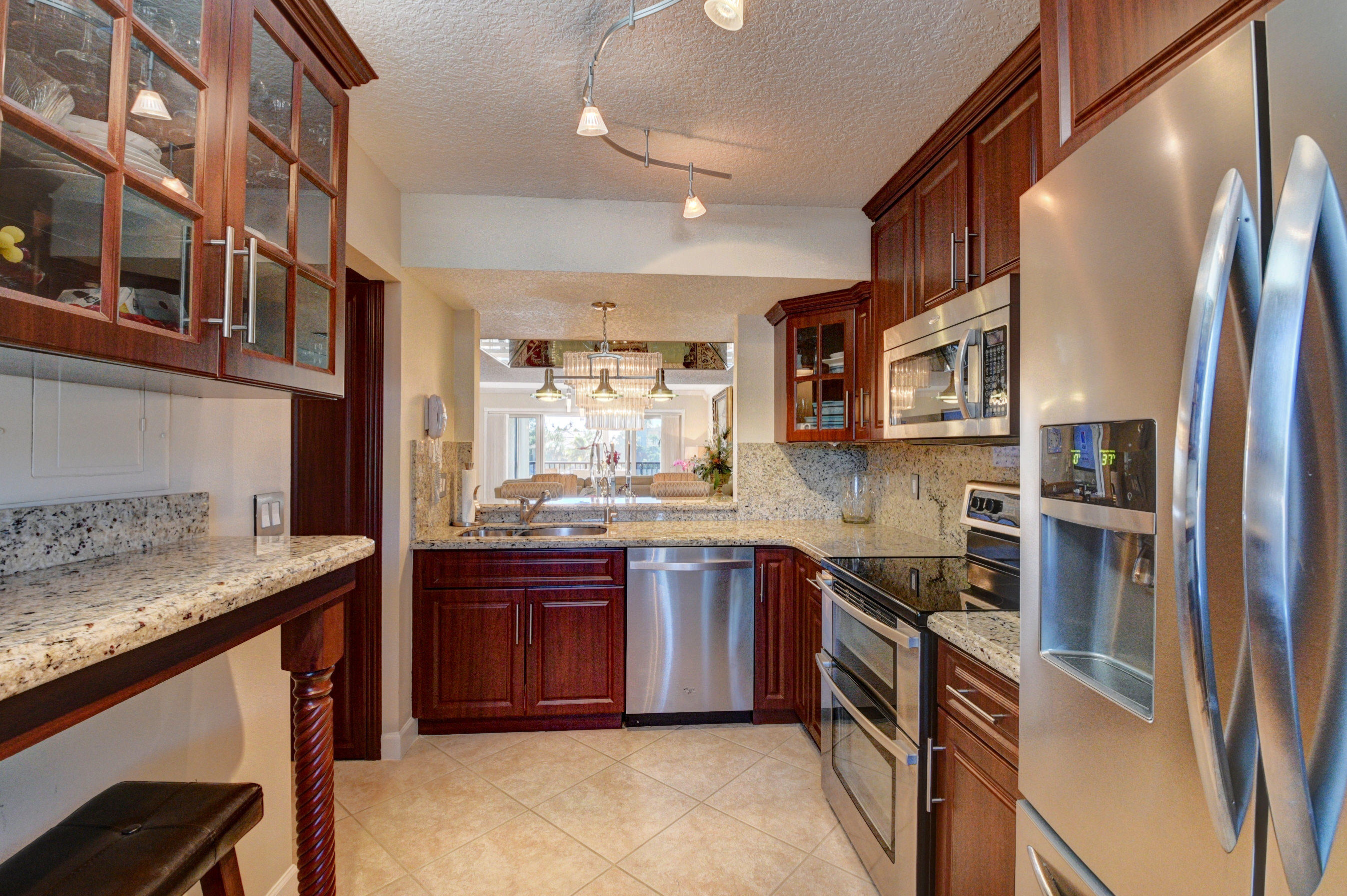 210 Captains Walk, Unit 710 Delray Beach, FL 33483 - Photo 14 of 49 a kitchen with stainless steel appliances granite countertop a sink and wooden cabinets