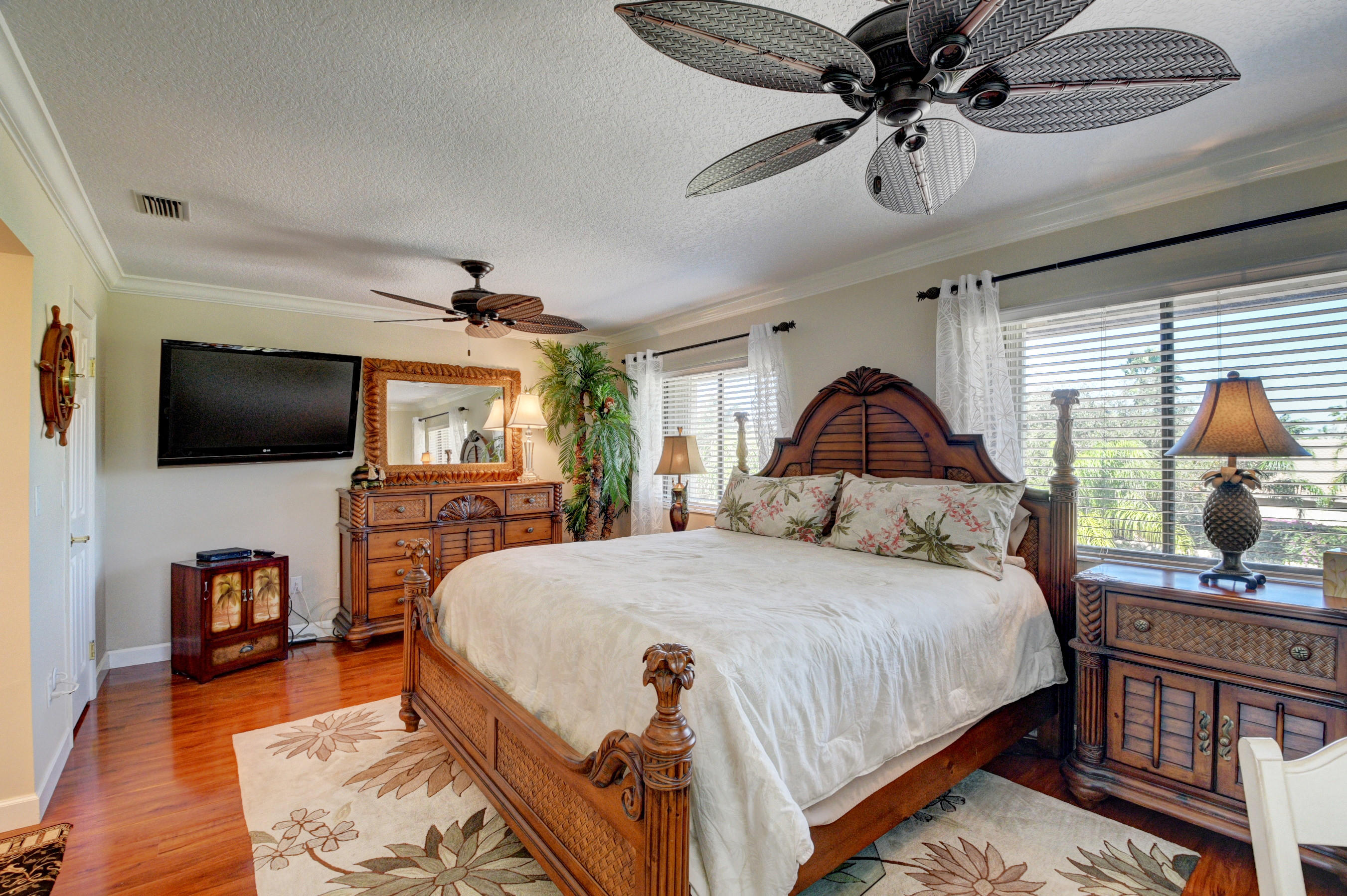 210 Captains Walk, Unit 710 Delray Beach, FL 33483 - Photo 16 of 49 a spacious bedroom with a bed and a flat screen tv