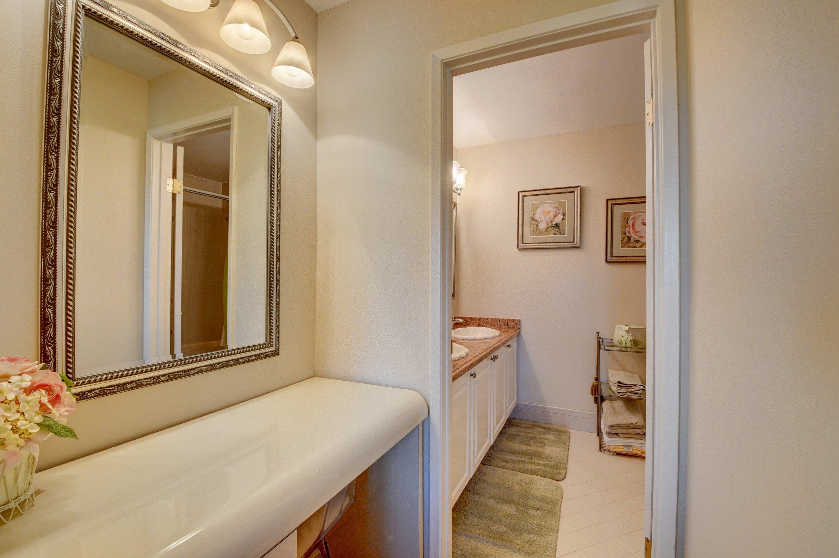210 Captains Walk, Unit 710 Delray Beach, FL 33483 - Photo 18 of 49 a hallway with white cabinets and wooden floor