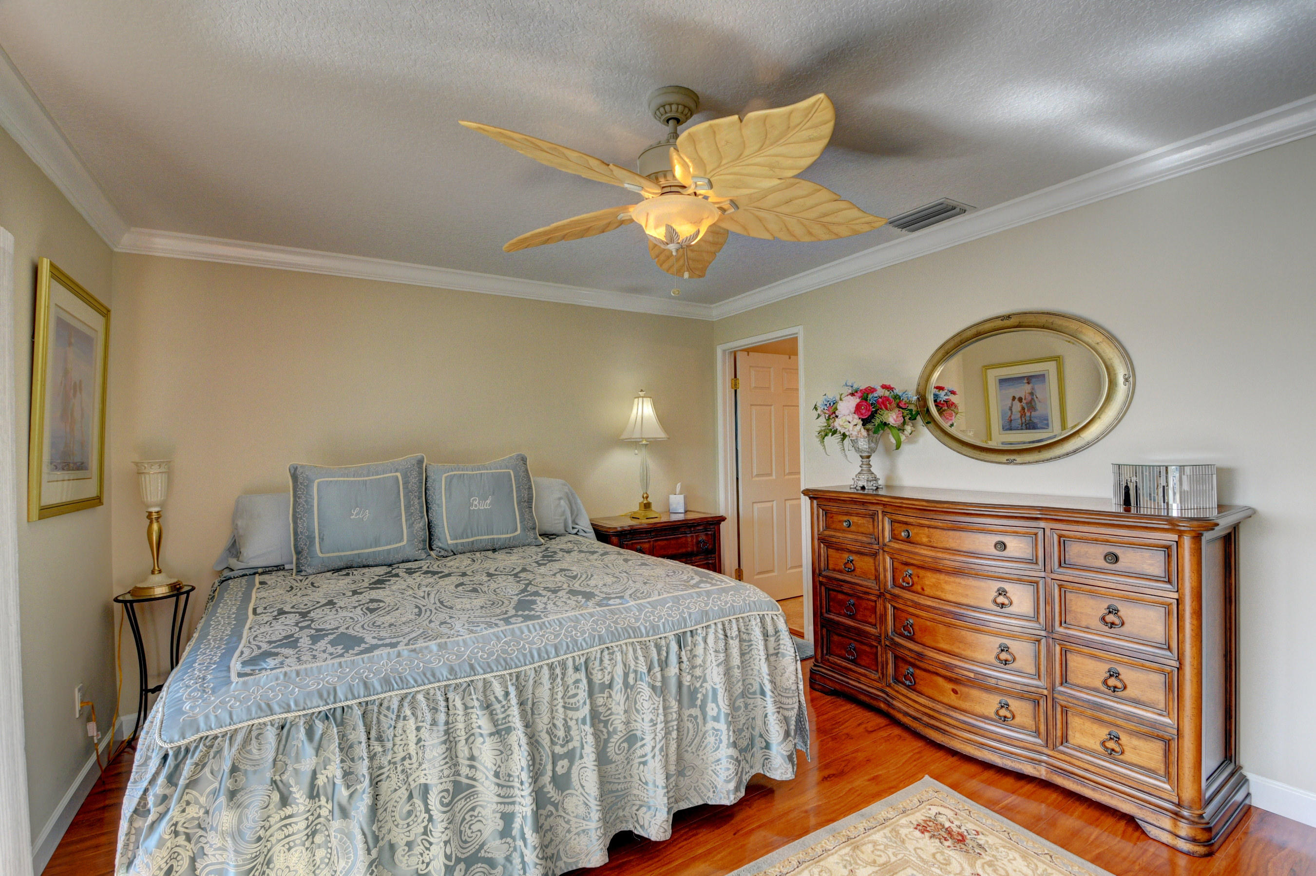 210 Captains Walk, Unit 710 Delray Beach, FL 33483 - Photo 22 of 49 a bedroom with a bed a mirror on the dresser and a chandelier