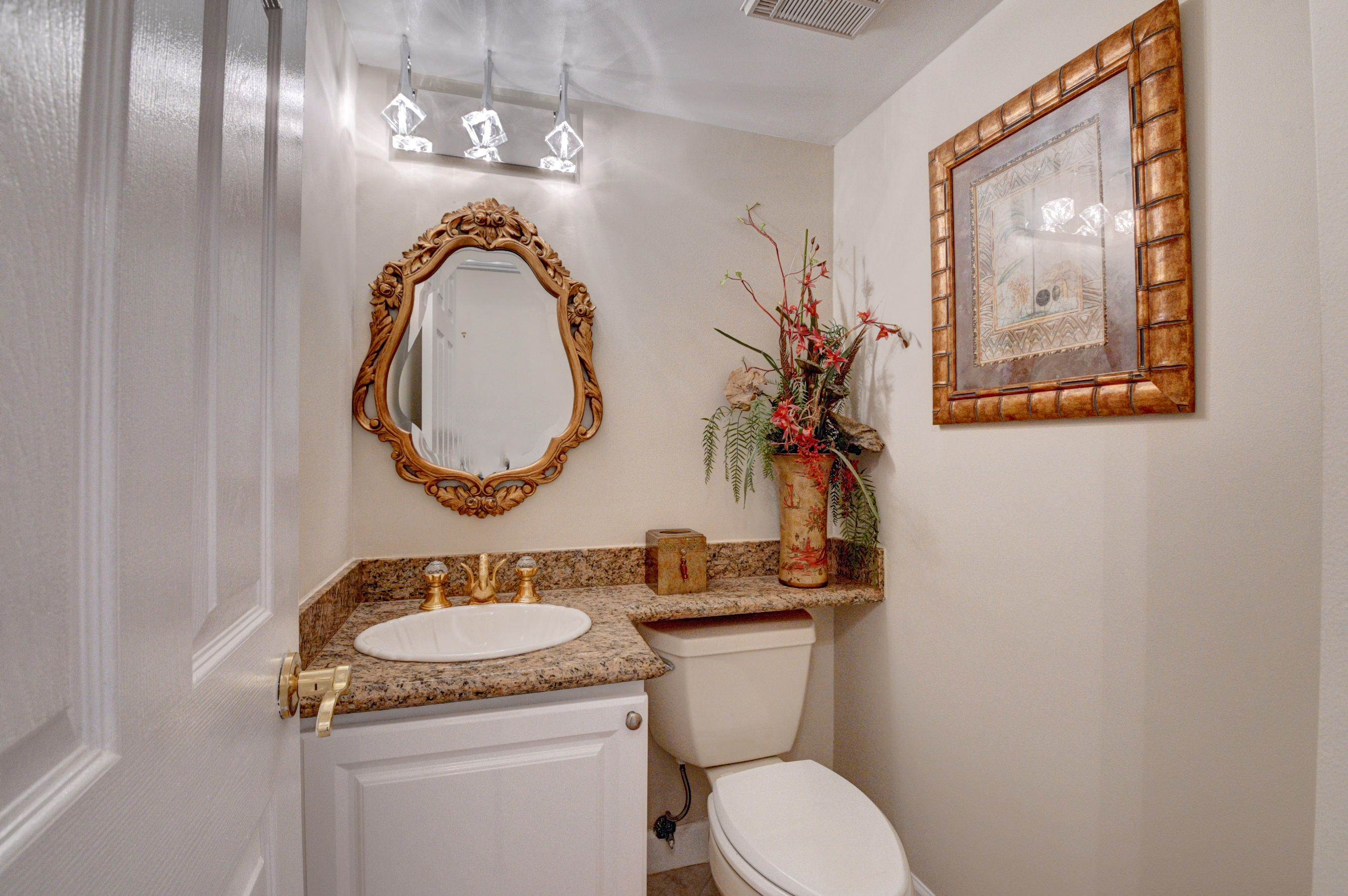 210 Captains Walk, Unit 710 Delray Beach, FL 33483 - Photo 27 of 49 a bathroom with a granite countertop toilet a sink and a mirror