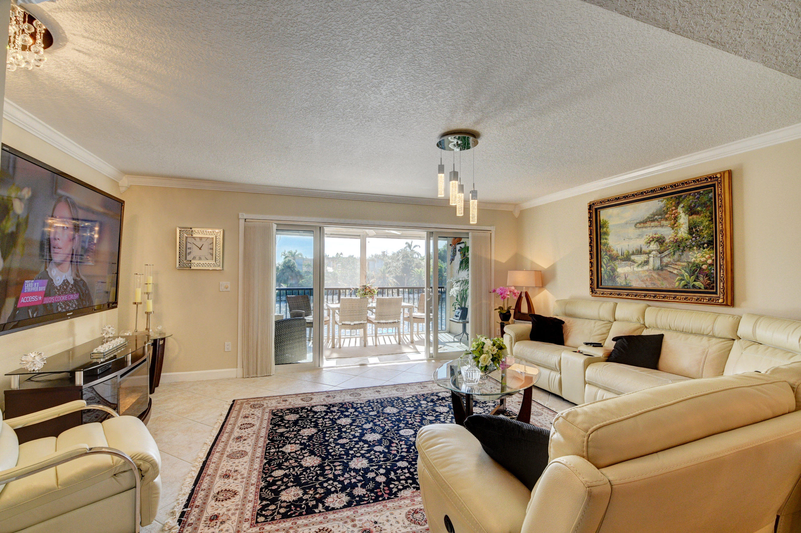 210 Captains Walk, Unit 710 Delray Beach, FL 33483 - Photo 7 of 49 a living room with furniture and a flat screen tv