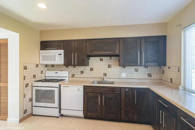 a kitchen with a sink a stove and cabinets
