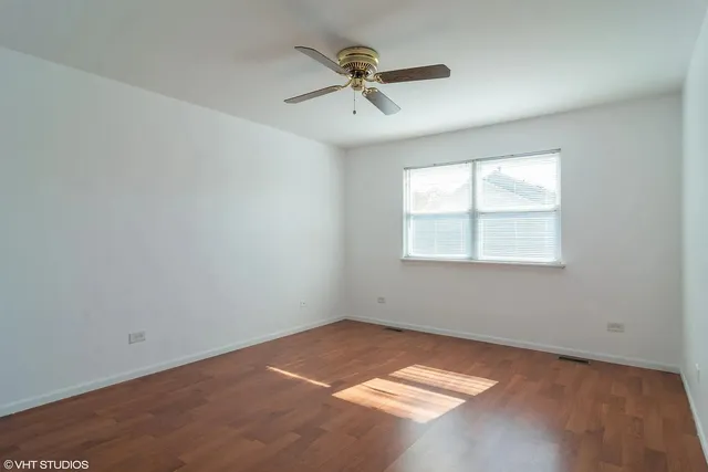 an empty room with a window and a ceiling fan