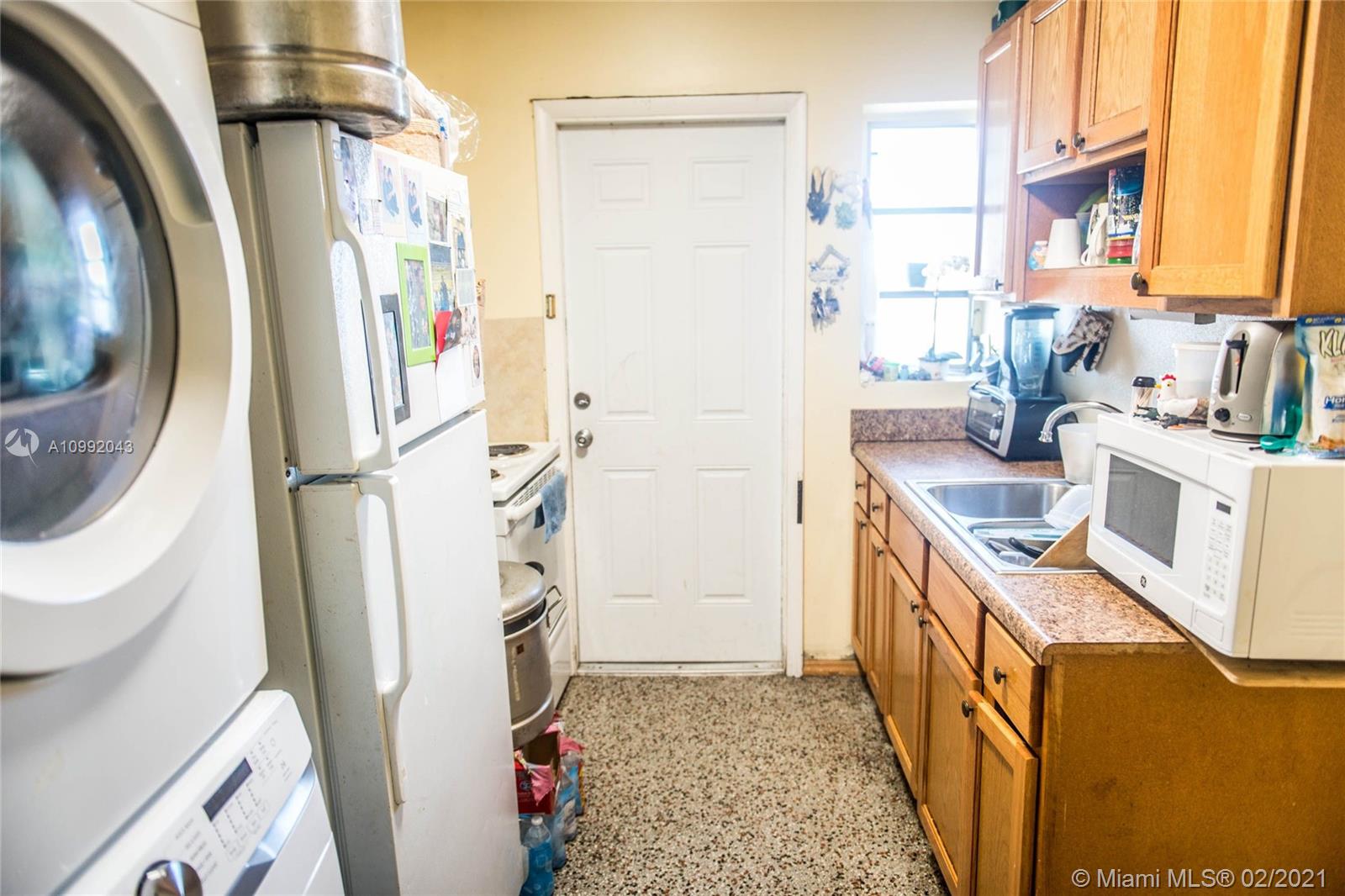 105 Northeast 2nd Road Homestead, FL 33030 - Photo 15 of 26 a kitchen with a refrigerator a stove a washer dryer and a sink