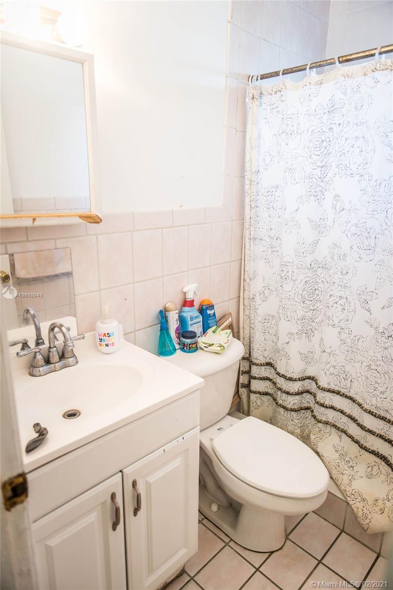 105 Northeast 2nd Road Homestead, FL 33030 - Photo 18 of 26 a bathroom with a sink a toilet and shower curtain