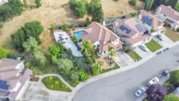a front view of a house with a garden and trees