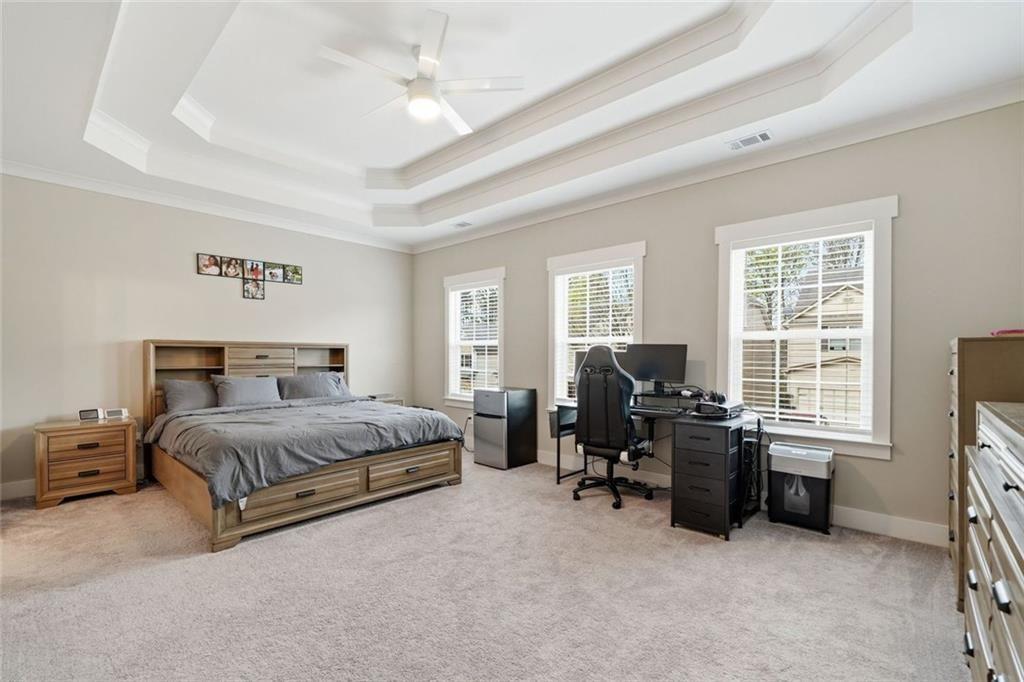 241 Bethany Manor Court Ball Ground, GA 30107 - Photo 21 of 36 a spacious bedroom with a bed couch table and a window