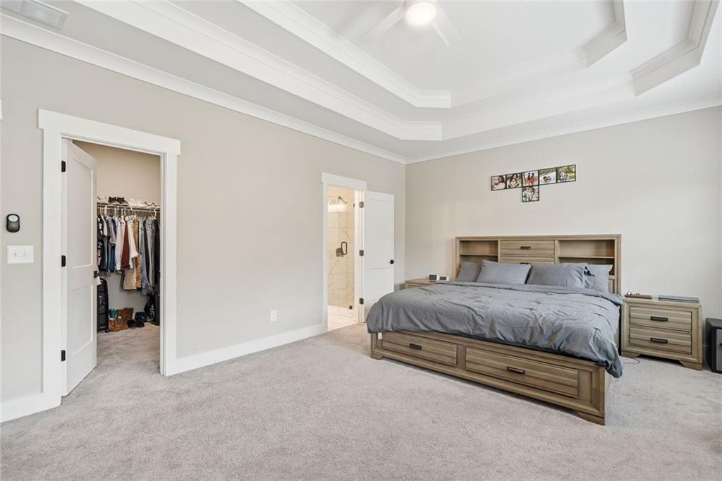 241 Bethany Manor Court Ball Ground, GA 30107 - Photo 22 of 36 a spacious bedroom with a bed and a lamp