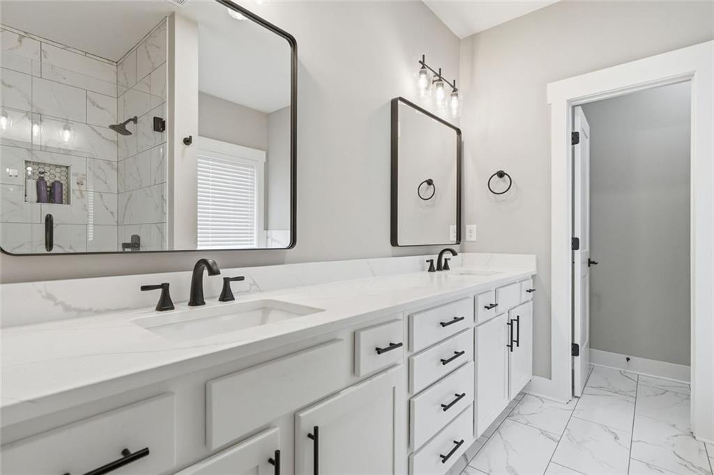241 Bethany Manor Court Ball Ground, GA 30107 - Photo 25 of 36 a bathroom with double sink and a mirror