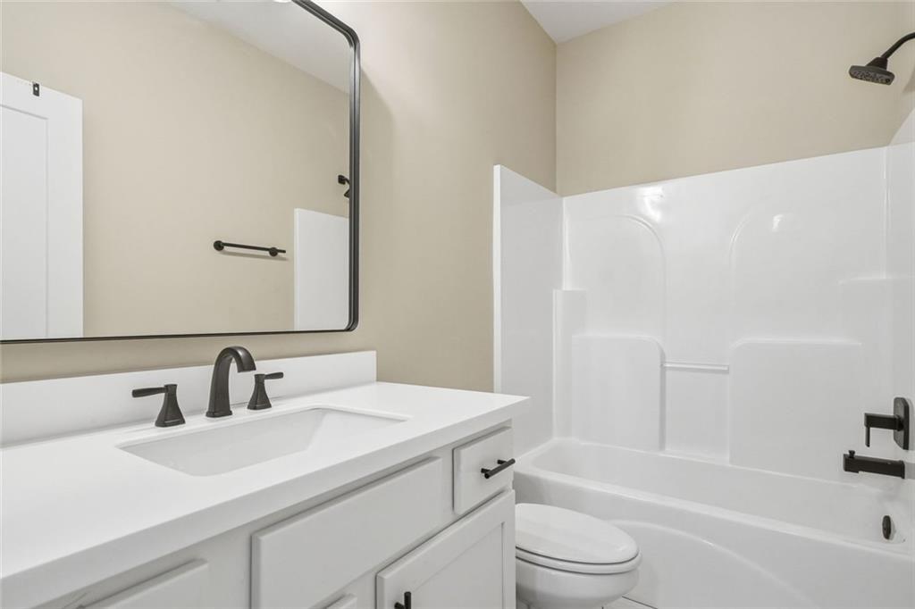 241 Bethany Manor Court Ball Ground, GA 30107 - Photo 28 of 36 a bathroom with a sink a toilet and a bathtub