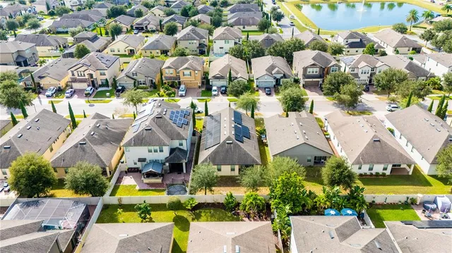 an aerial view of a house with swimming pool and outdoor seating