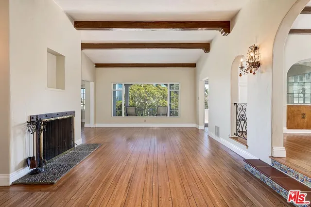 a view of a room with wooden floor mirror and windows