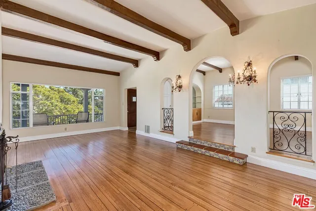 a view of empty room with wooden floor and fireplace