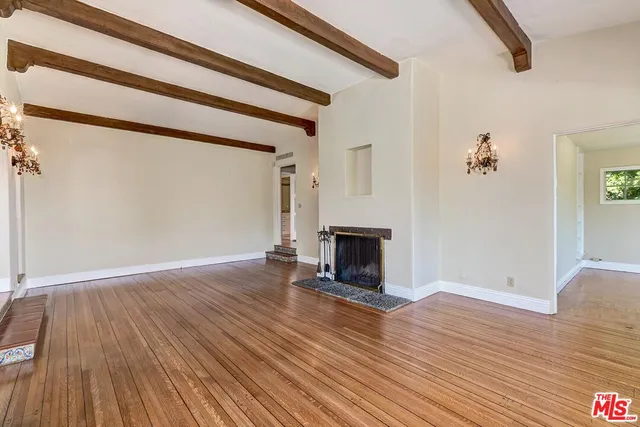 a view of a livingroom with wooden floor and staircase