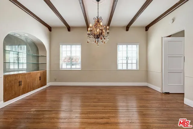 a kitchen with stainless steel appliances granite countertop a refrigerator a sink dishwasher a stove and white countertops with wooden floor