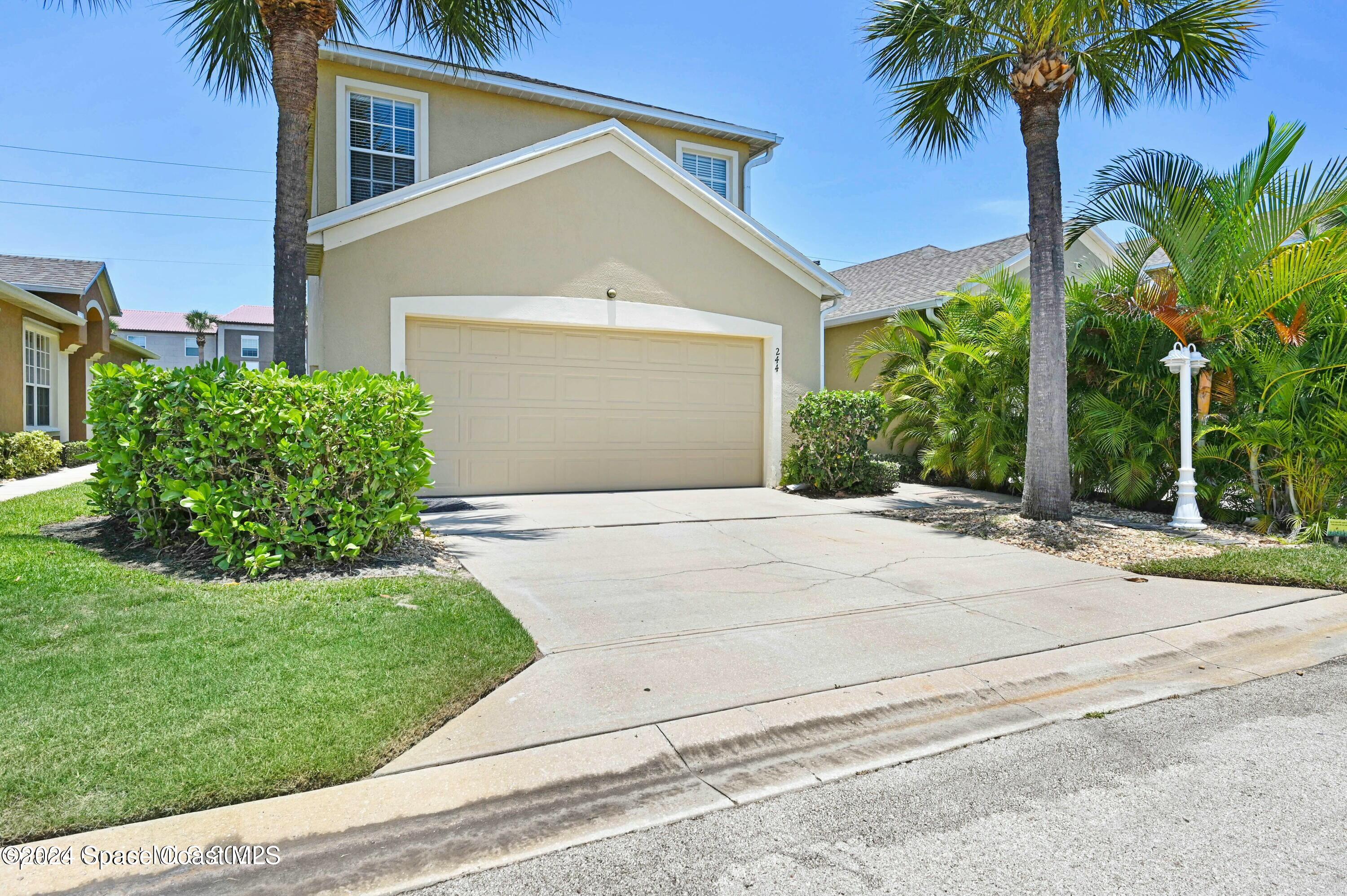 244 Intrepid Way Indialantic, FL 32903 - Photo 2 of 42 a front view of a house with a yard and garage