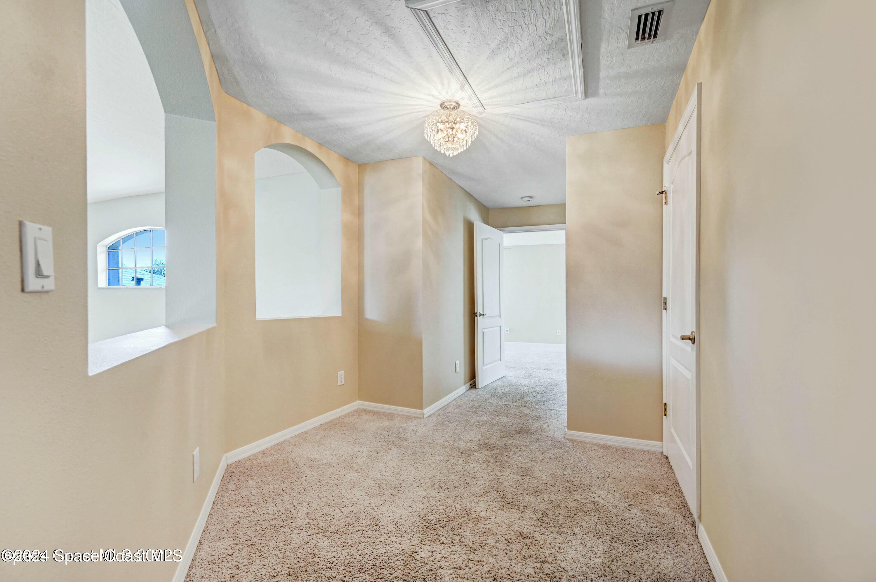 244 Intrepid Way Indialantic, FL 32903 - Photo 26 of 42 a view of a hallway with a chandelier