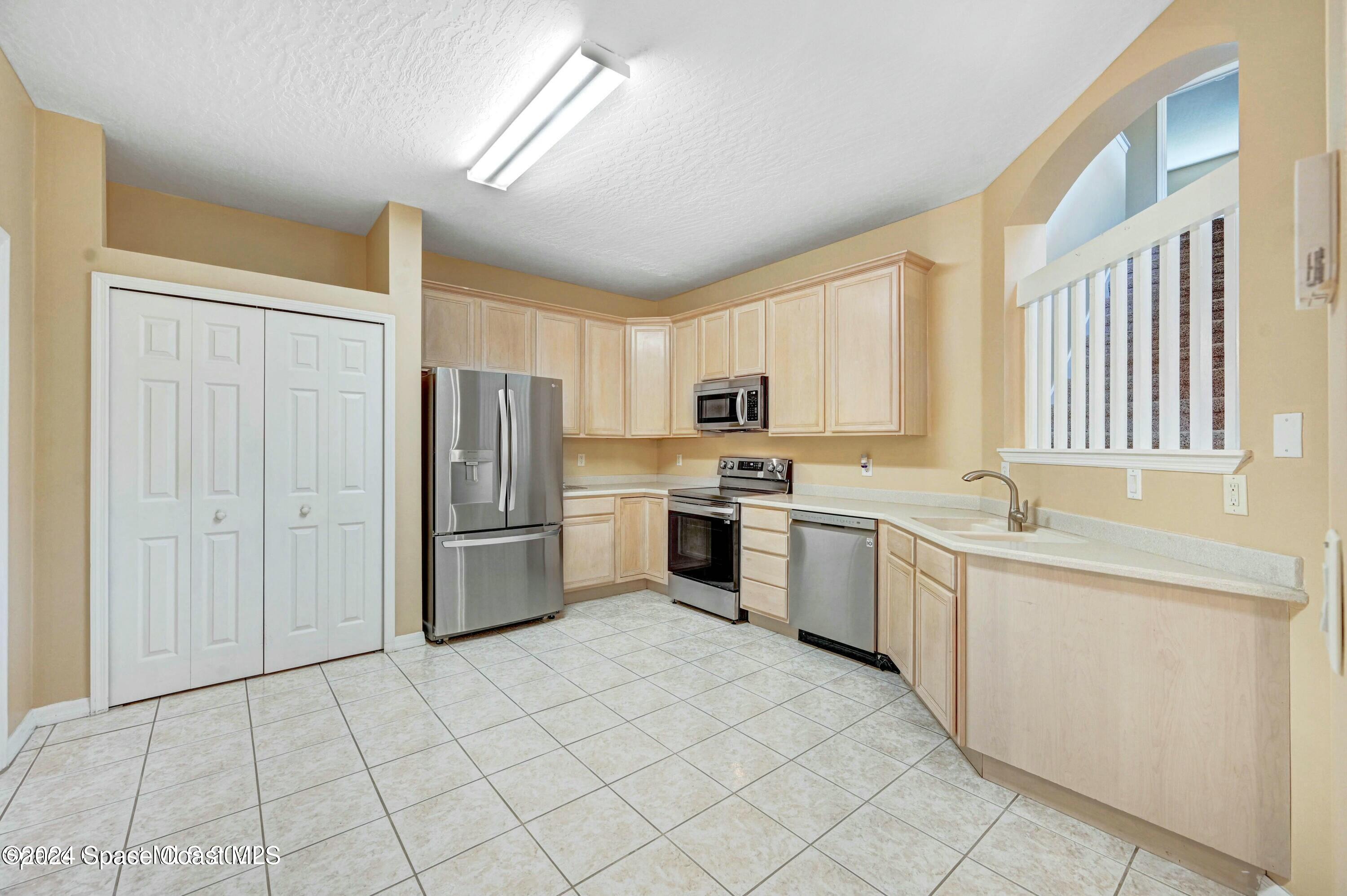 244 Intrepid Way Indialantic, FL 32903 - Photo 6 of 42 a kitchen with a sink a counter top space stainless steel appliances cabinets and a window