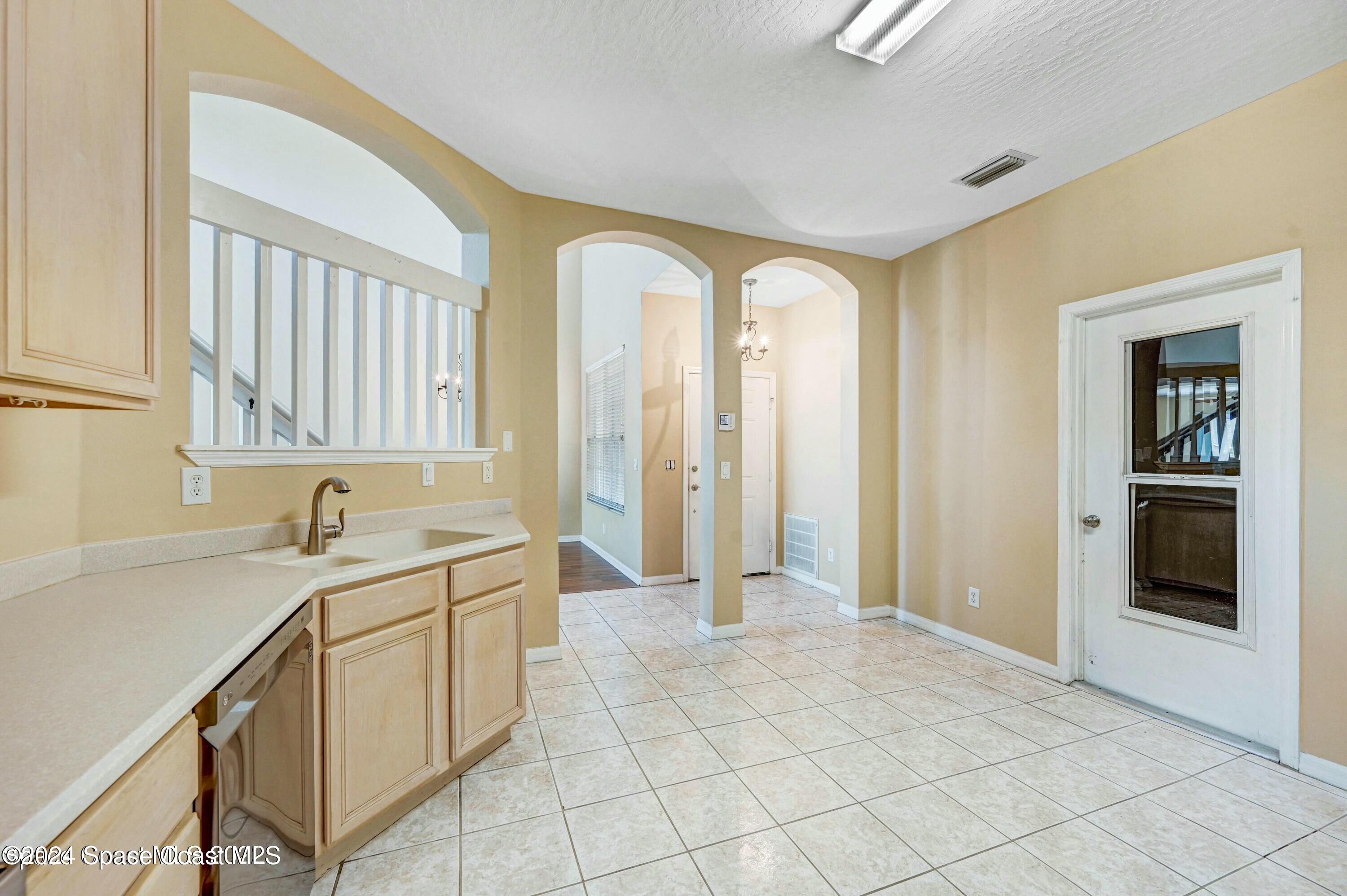 244 Intrepid Way Indialantic, FL 32903 - Photo 8 of 42 a view of a kitchen with white cabinets and a sink