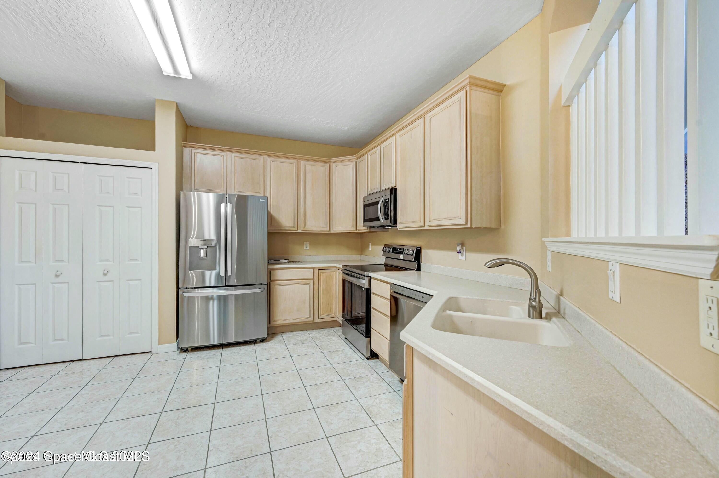 244 Intrepid Way Indialantic, FL 32903 - Photo 9 of 42 a kitchen with a sink a refrigerator and cabinets