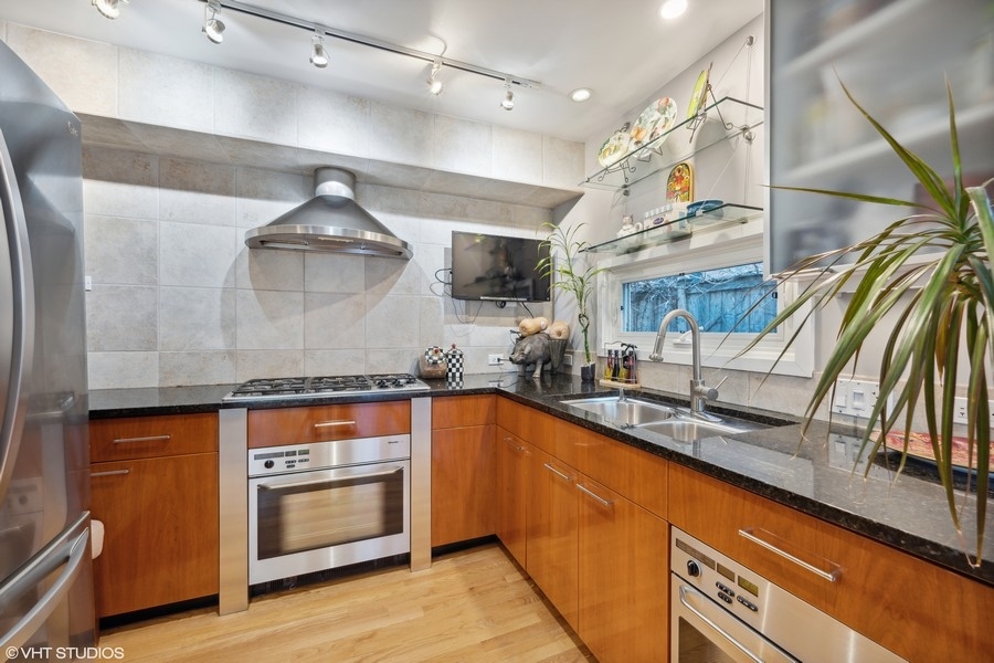 290 Poplar Street Winnetka, IL 60093 - Photo 15 of 55 a kitchen with stainless steel appliances granite countertop a sink a stove and a wooden floors