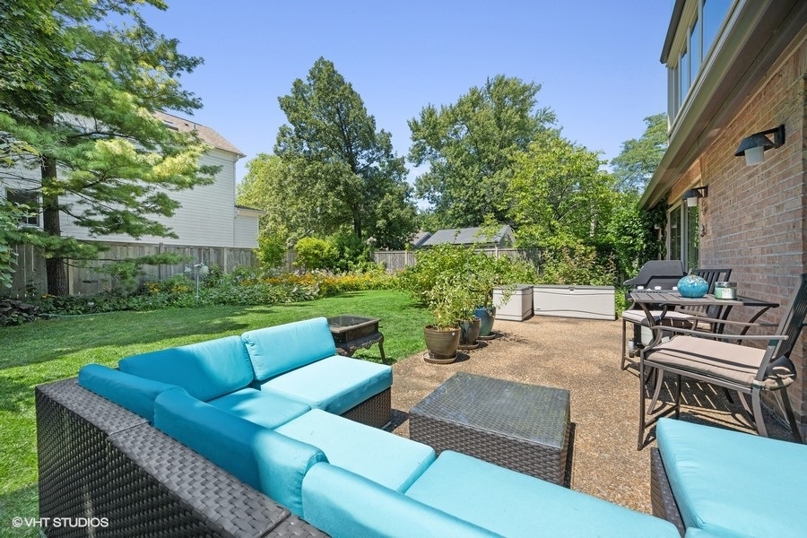 290 Poplar Street Winnetka, IL 60093 - Photo 19 of 55 a view of a patio with couches chairs potted plants and a big yard