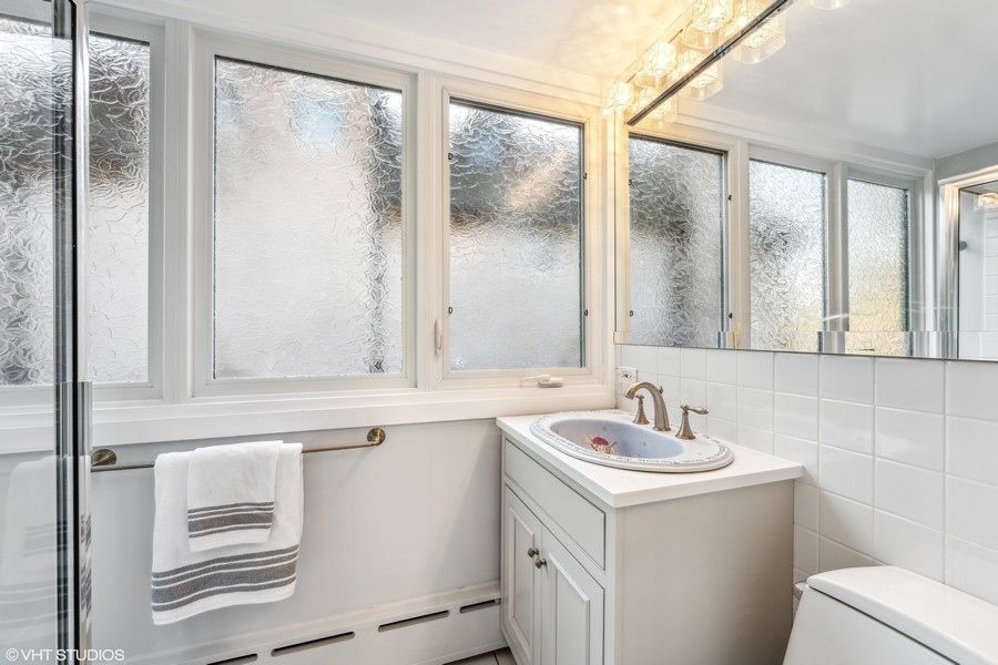 290 Poplar Street Winnetka, IL 60093 - Photo 30 of 55 a bathroom with a sink and a mirror