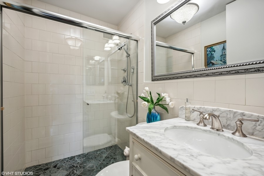 290 Poplar Street Winnetka, IL 60093 - Photo 42 of 55 a bathroom with a granite countertop sink a mirror a shower and a toilet