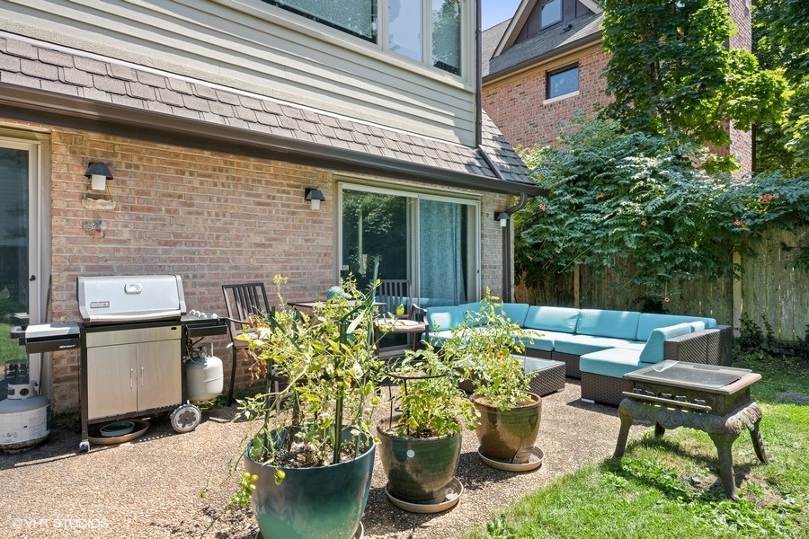 290 Poplar Street Winnetka, IL 60093 - Photo 48 of 55 a view of a patio with table and chairs potted plants and a bench