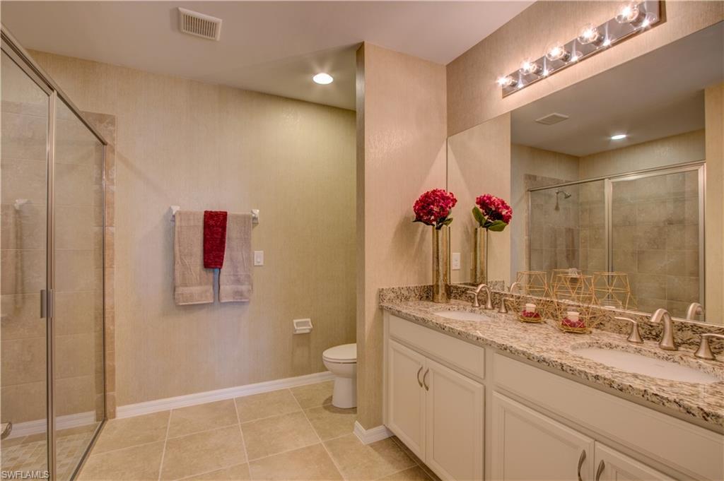 14533 Edgewater Circle Naples, FL 34114 - Photo 12 of 24 a bathroom with a granite countertop sink a toilet and a mirror