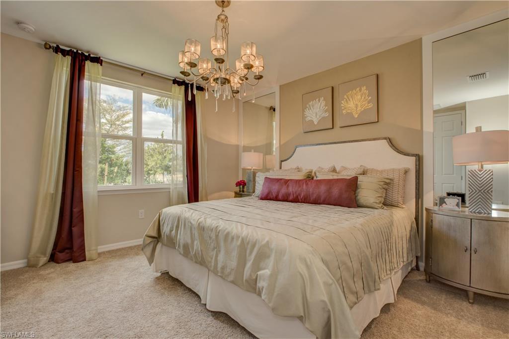14533 Edgewater Circle Naples, FL 34114 - Photo 7 of 24 a bedroom with a large bed and a chandelier