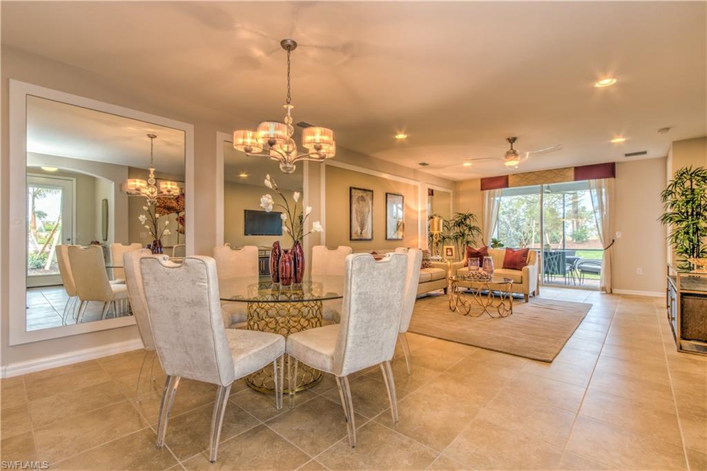 14533 Edgewater Circle Naples, FL 34114 - Photo 9 of 24 a dining room with furniture a chandelier and wooden floor